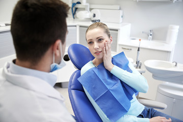 Obraz premium male dentist with woman patient at clinic