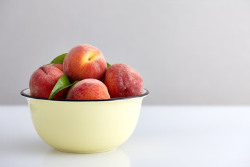 Ripe peaches in bowl isolated on white