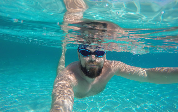 Man doing underwater selfie shot in deep blue sea