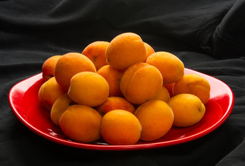 fresh apricots in red plate