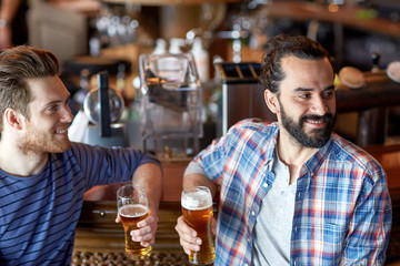 happy male friends drinking beer at bar or pub