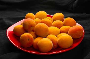 fresh apricots in red plate