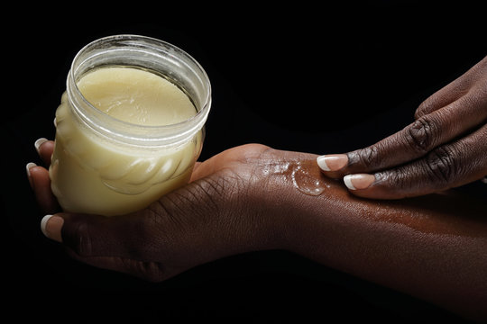 femme noire africaine mettant beurre de karité sur sa peau
