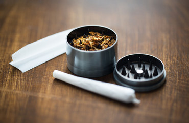 close up of marijuana joint and herb grinder