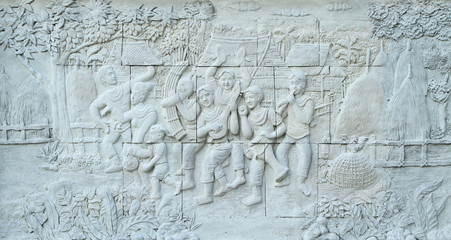 Fototapeta na wymiar Stone carving of traditional Thai musical instrument on temple wall
