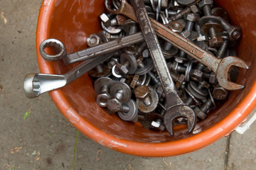 Nut and bolt and wrench in the bucket