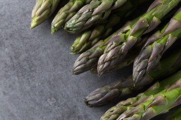 Bunch of asparagus on a table. Uncooked pile raw for organic, vegetarian cuisine, delicious fresh, healthy ingredient. Closeup and copy space.
