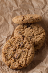 Cookies pile with chocolate chip on light textile background. Delicious morning snacks for breakfast, brunch and lunch. Appetizing, healthy, sweet, scrummy, and fast food.