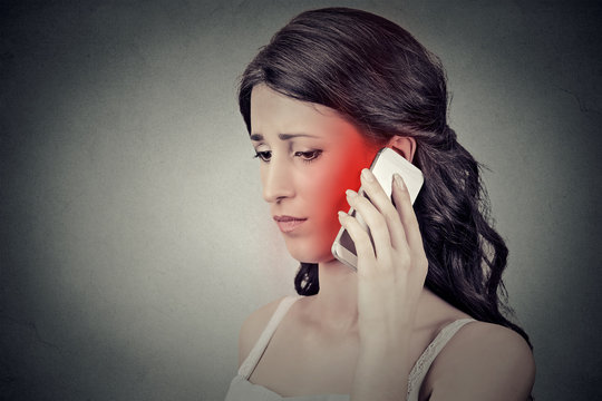 Concerned Young Woman Talking On Mobile Phone Having Pain Headache