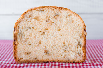 Loaf of white bread with green pumpkin seeds