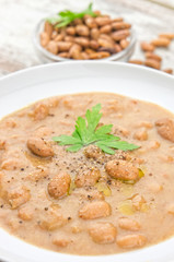 Bean soup in a plate on wooden table