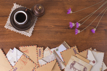 Envelopes on a wood background with a cup of coffee