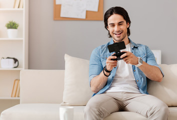 Positive smiling man playing video games