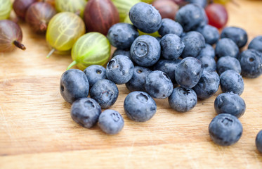 Fresh blueberry and gooseberry on the wooden table - food picture