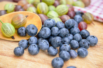 Fresh blueberry and gooseberry on the wooden table - food picture