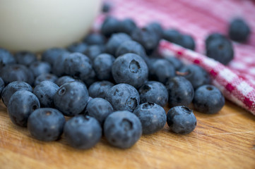 Fresh Blueberry on the wooden table and cup of Milk