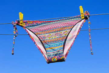 Drying woman swimsuit against the blue sky