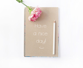 Notepad and flower with motivational sample text