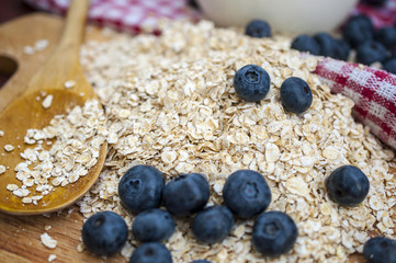 Oat flakes on the wooden table with milk and blueberry