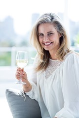 Smiling woman holding wineglass at home