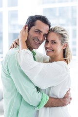 Portrait of romantic couple embracing at home