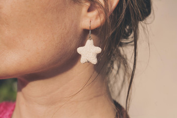 woman wearing white star earring