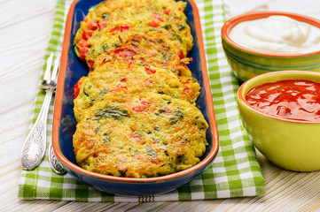 Vegetarian cuisine - vegetable fritters (with potatoes, carrot, zucchini, paprika and parsley) served with yogurt sauce.