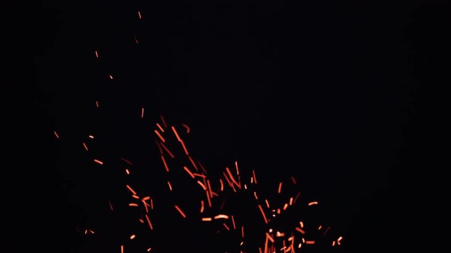 fire flames with sparks from campfire over black background
