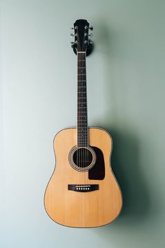 Acoustic guitar on guitar holder on the wall
