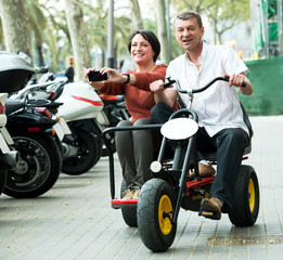 Fototapeta na wymiar Couple traveling through city by twin bicycle