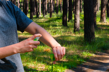 girl in the forest uses the spray against mosquitoes