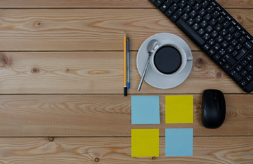 keyboard, colored stickers cup of coffee and office supplies 