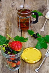 Strawberry, Black Currant and Tea on Wooden Rustic Background