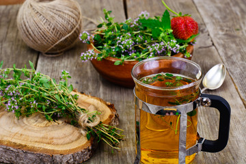 Herbal Tea with Thyme, Mint and Cinnamon on Wooden Rustic Backgr