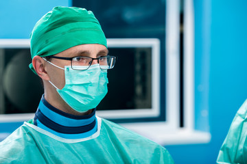 Fototapeta na wymiar Young orthopedic surgeons portraiture with sterile mask and cap