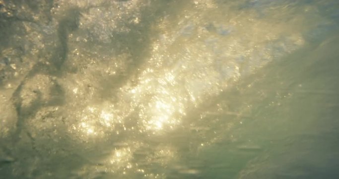 Beautiful ocean wave breaking at sunset in slow motion