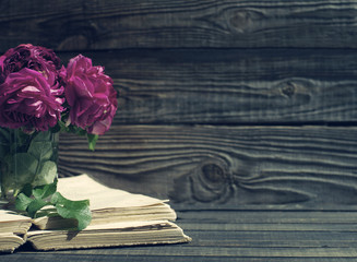 Garden pink roses and old books on a wooden surface