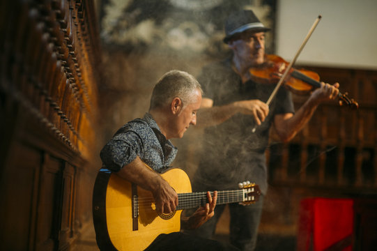 Musicians performing with guitar and vionin.