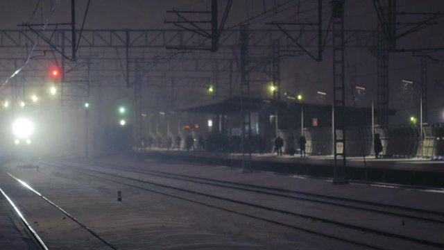 A train passing a station in snow (slow motion)