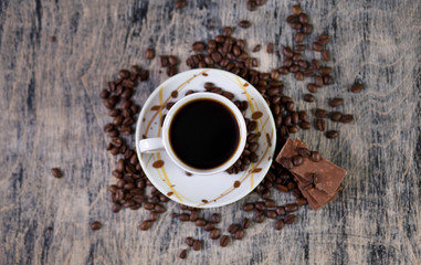 Чашка кофе и шоколад на фоне зернового кофе