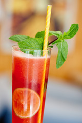 Raspberry-chocolate black tea with ice in a glass beaker on a wooden table