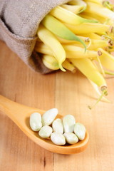 Fototapeta na wymiar Seeds and heap of yellow beans in jute bag, healthy food