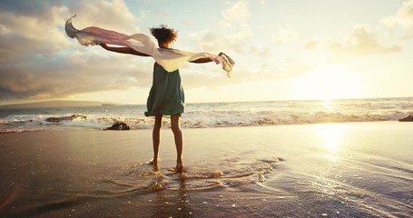 Beautiful young woman playing on the beach in slow motion at sunset, soft warm vintage color tone