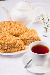 cake Napoleon and kettle with tea