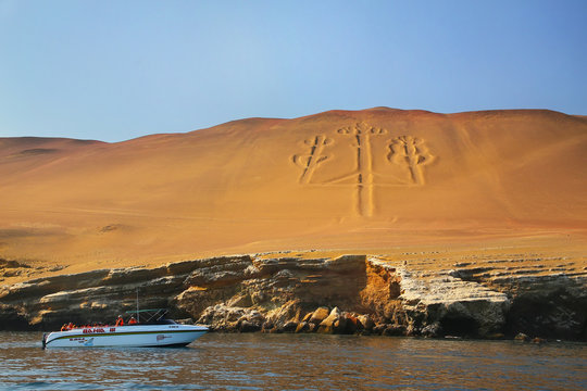 Tourist group in a boat near Candelabra of the Andes in Pisco Ba