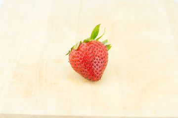 Red berry strawberry isolated on wood background
