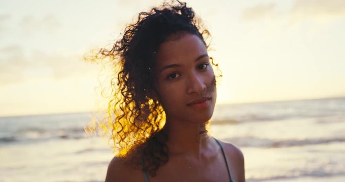 Portrait of beautiful young african american woman on the beach at sunset, soft warm vintage color tone