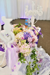 Beautiful wedding restaurant for marriage. White decor for bride and groom. Colorful decoration for celebration. Beauty bridal interior. Bouquet, food and flowers in hall