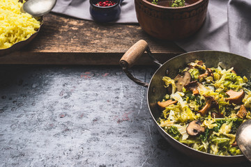 Stewed cabbage dish with mushrooms , preparation on dark rustic background