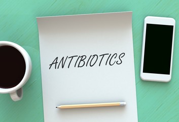 ANTIBIOTICS, message on paper, smart phone and coffee on table, 3D rendering